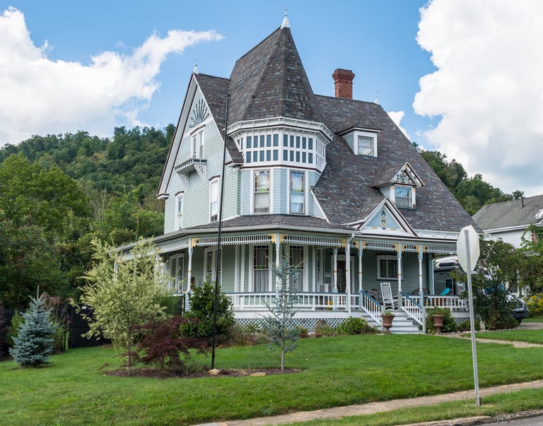 An old Victorian home located on a corner lot at Elm and Main Street on a sunny summer day