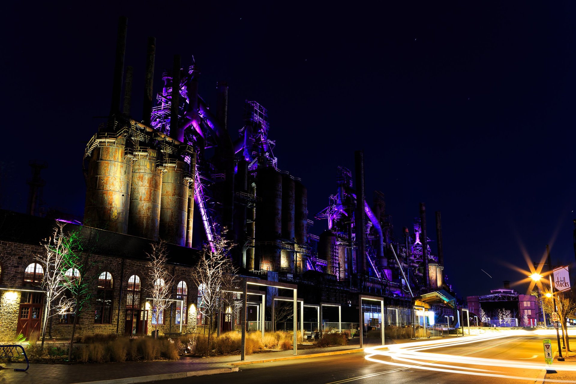 Bethlehem Steel Stacks turned into public entertainment area in downtown with concert center lit at nighttime with multi colored lights