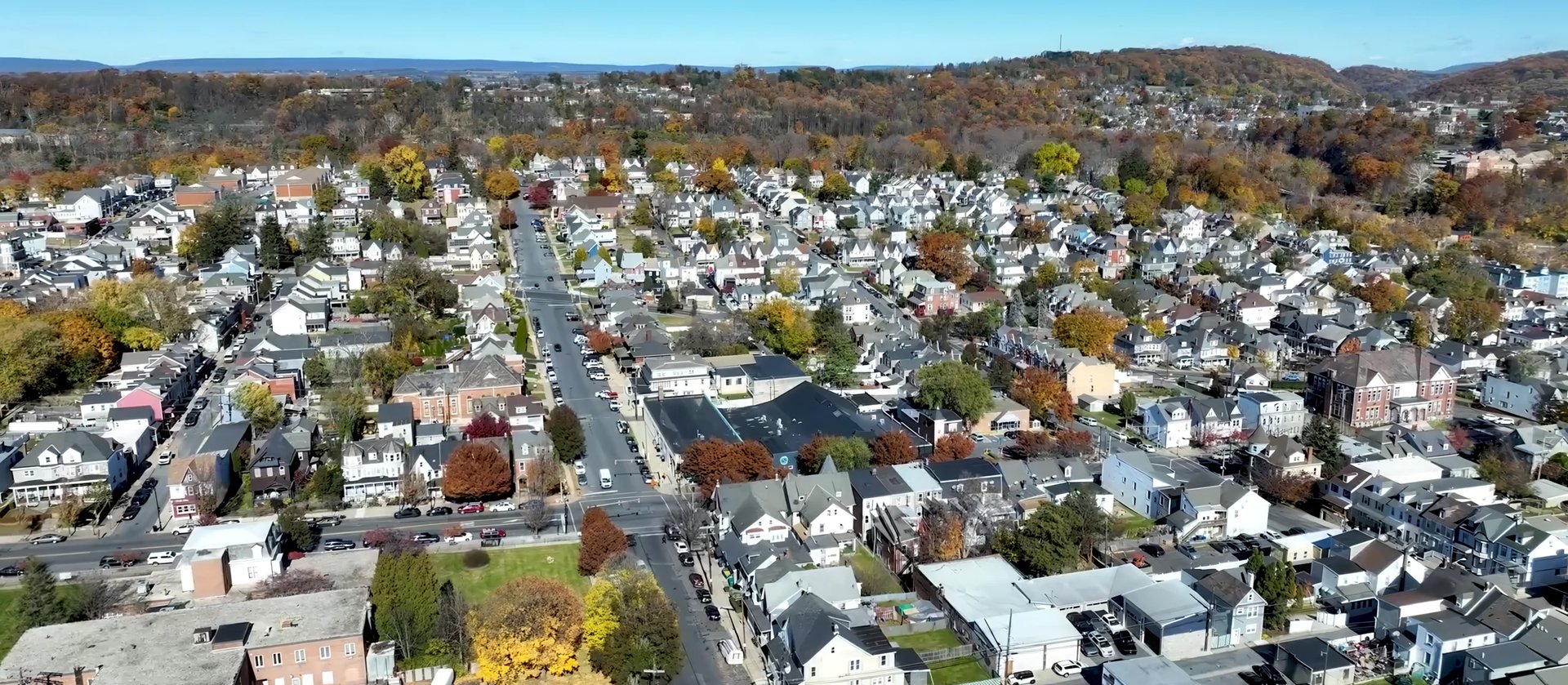 Aerial view of Easton, Pennsylvania residential suburban neighborhood with tree-lined streets, houses, and tree-covered hills in the background